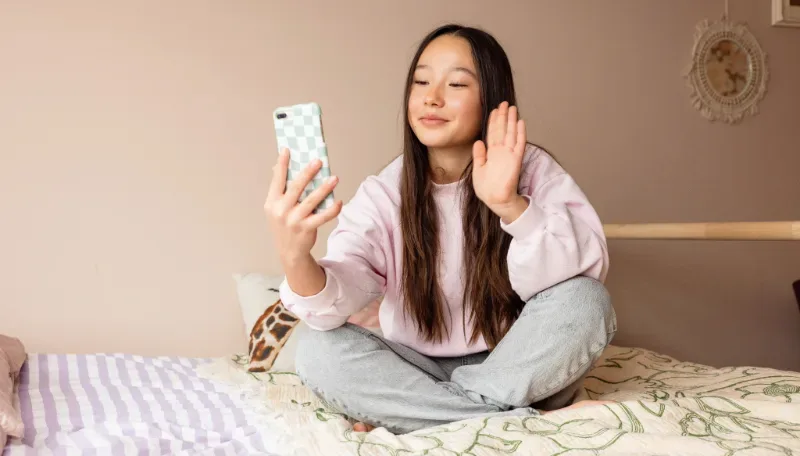 Meisje zwaait tijdens een videogesprek op haar telefoon