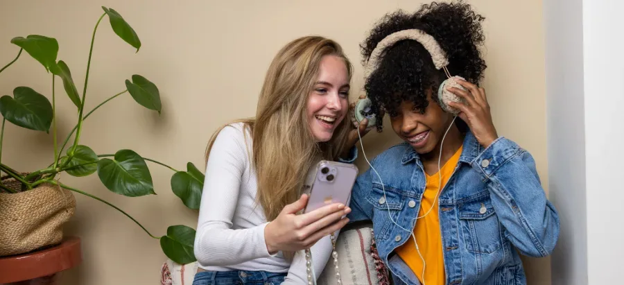 Twee meisjes luisteren samen naar muziek op een telefoon